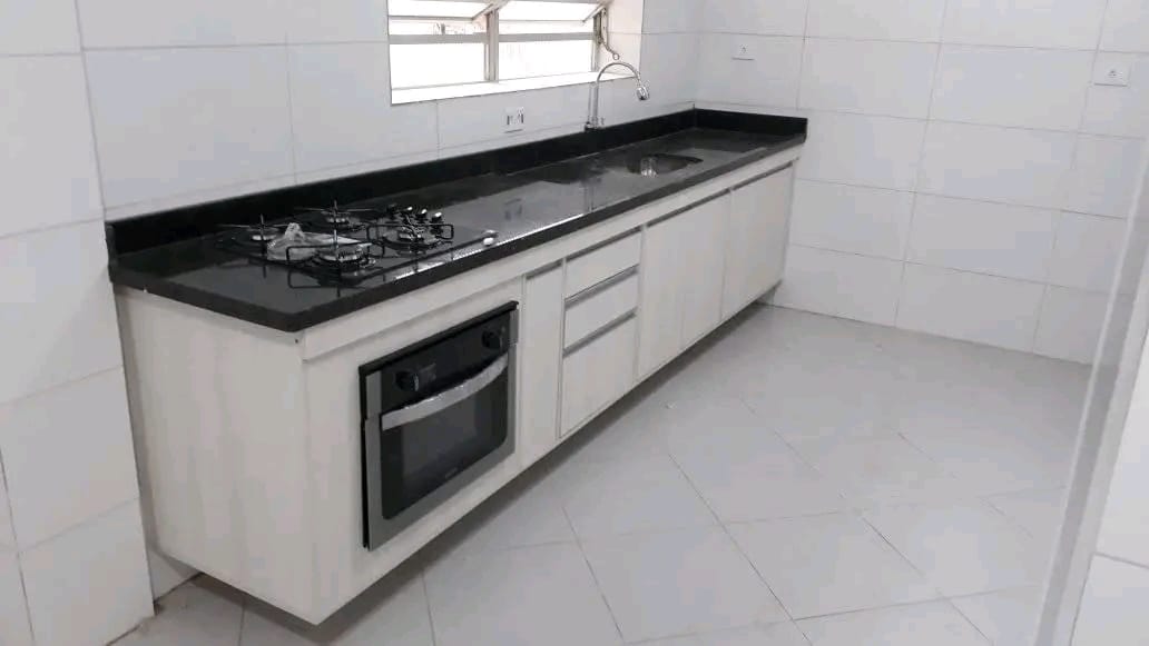 Cozinha sob medida com armários em MDF branco e bancada preta