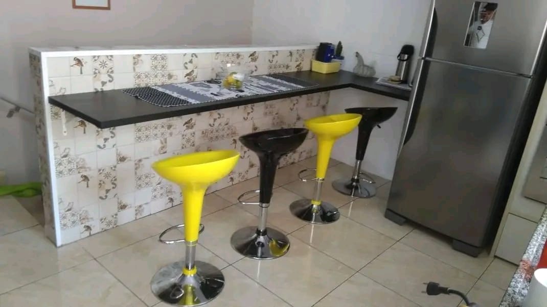 Balcão de cozinha com tampo preto e revestimento decorativo